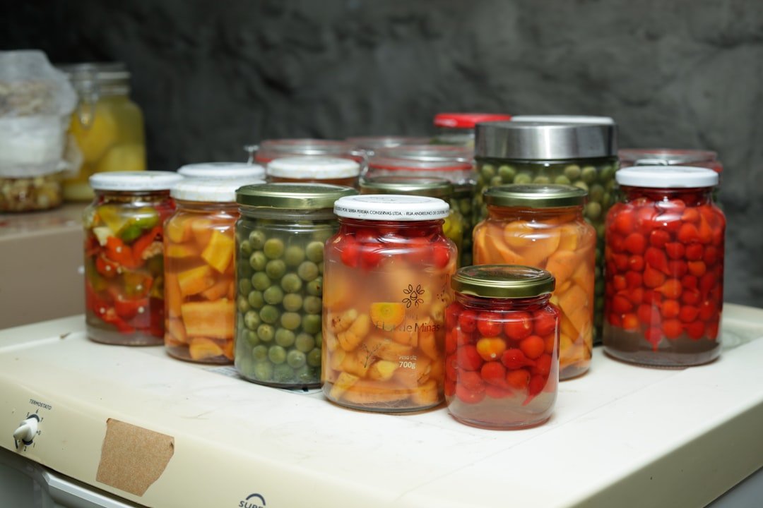 Glass jars of colorful fermented vegetables including pickled watermelon rind and kimchi